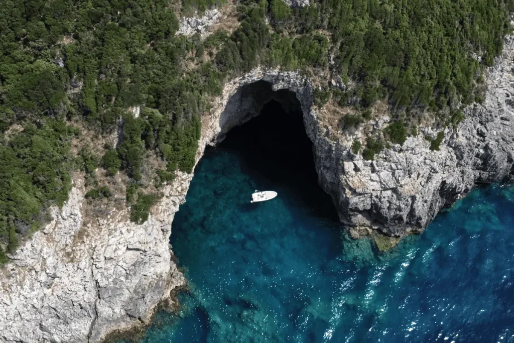Corfu High Seas rental boat over clear waters exploring a cave in Corfu